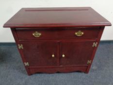 A stained oak double door cabinet fitted a drawer