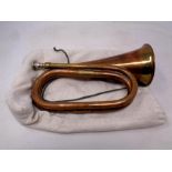 An antique copper and brass bugle in a bag