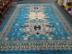 A machine made carpet of geometric design on a turquoise ground,
