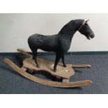 An Edwardian cloth upholstered rocking horse on wooden stand