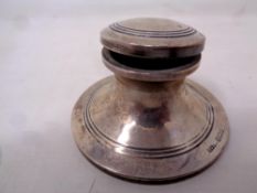 A small silver inkwell with glass liner,