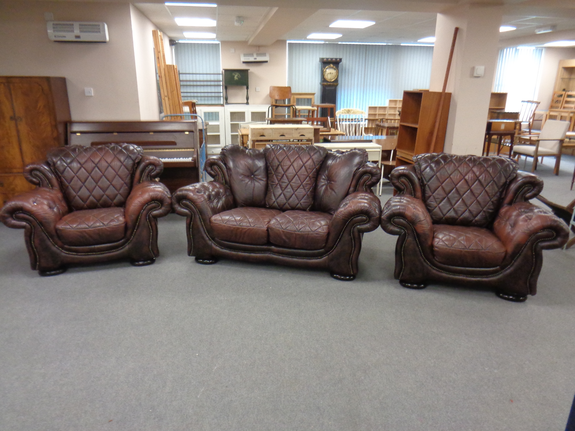 An Italian Rubelli three piece brown leather Chesterfield suite comprising two seater settee and