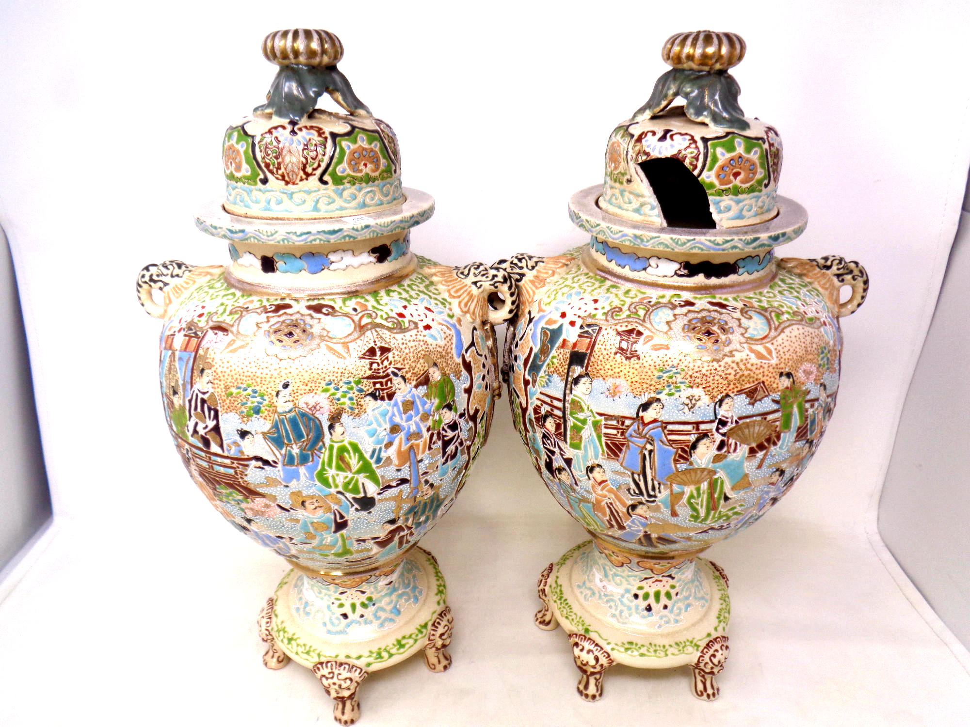 A pair of Chinese embossed crackle glazed lidded vases on raised feet, height 42.5 cm.