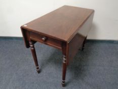 A Victorian mahogany flap sided table fitted with drawers