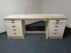 A stripped pine oversized dressing table fitted with ten drawers