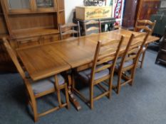 An Ercol refectory extending dining table and eight ladder back chairs
