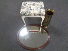 An oval framed mirror, cream and gilt floral dressing table stool, brass embossed stick pot,