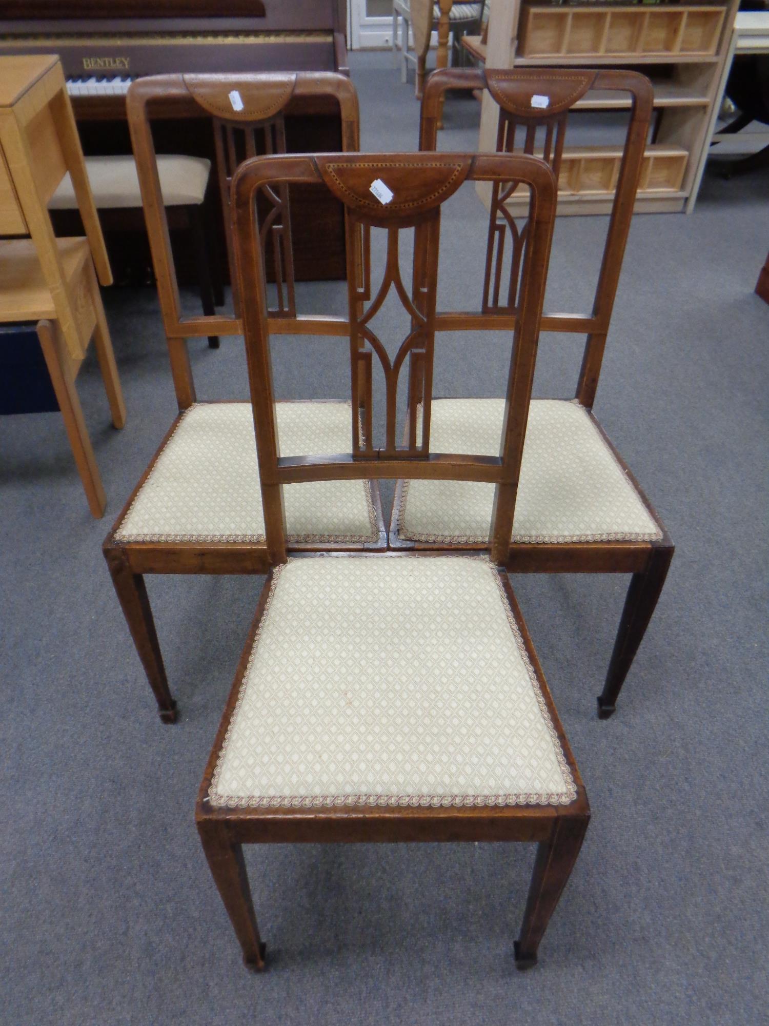 Three Edwardian inlaid mahogany dining chairs