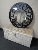 A contemporary circular wall mirror and a blanket box upholstered in velvet like fabric