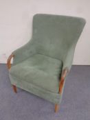 A contemporary beech armchair in green fabric