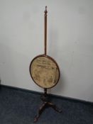 A Victorian mahogany pole screen on tripod base