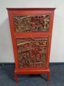 A painted Chinese style cabinet with gilt panel door on raised legs