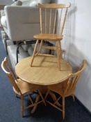 A circular pedestal kitchen table and four beech rail back chairs