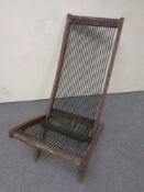 A folding teak garden steamer chair with rope webbing upholstery