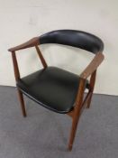 A mid 20th century black vinyl and teak low backed armchair