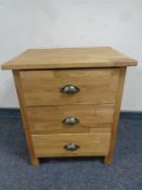A contemporary oak three drawer bedside chest