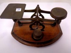 A set of 19th century brass postal scales mounted on a mahogany board with three graduated weights