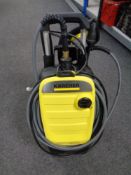 A Karcher pressure washer with hose and attachments