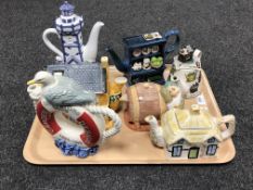 A tray containing seven assorted novelty teapots