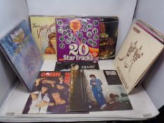 A box containing vinyl LPs and 12" singles to include Elvis, Queen, Billy Joel, Rick Wakeman etc.