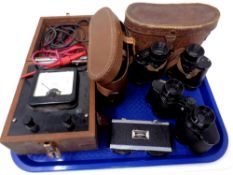 Two pairs of field glasses in leather cases together with a camera and a vintage volt meter in a