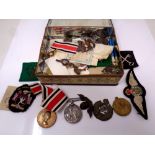 A tin containing WWI medals, cat badges, buttons and sew on badges.