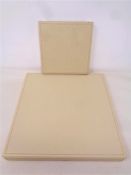 Two Rolex cream stitched leather watch display trays, 15 cm x 15 cm and 25 cm x 25 cm,