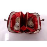 A vintage miniature purse containing silver three pence pieces.