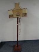 A wooden Art Deco standard lamp with a hand stitched tasseled shade depicting galleons