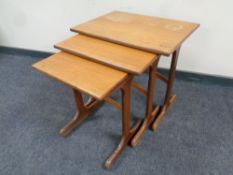 A nest of three 20th century teak G Plan tables together with a further nest of three leather