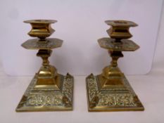 A pair of decorative Victorian brass candlesticks.