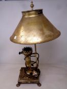 A brass retro style table lamp in the form of an oil lamp on paw feet.