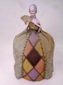 A Victorian porcelain and fabric pin cushion in the form of a lady