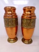A pair of copper and brass vases with embossed band depicting musicians.