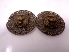 Two antique filigree metal lion mask belt buckles.