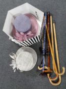 A box containing three formal lady's hats together with a bundle of assorted walking sticks