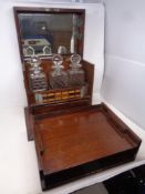 A 19th century oak three-bottle decanter box containing internal drawers, cribbage board,