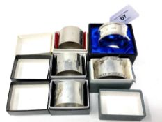 Five boxed silver napkin rings including two Lindisfarne examples.