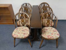 An Ercol solid elm and beech drop leaf table together with set of six Fleur de Lys dining chairs