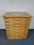 A good quality eight drawer glass topped collector's chest containing a large quantity of assorted