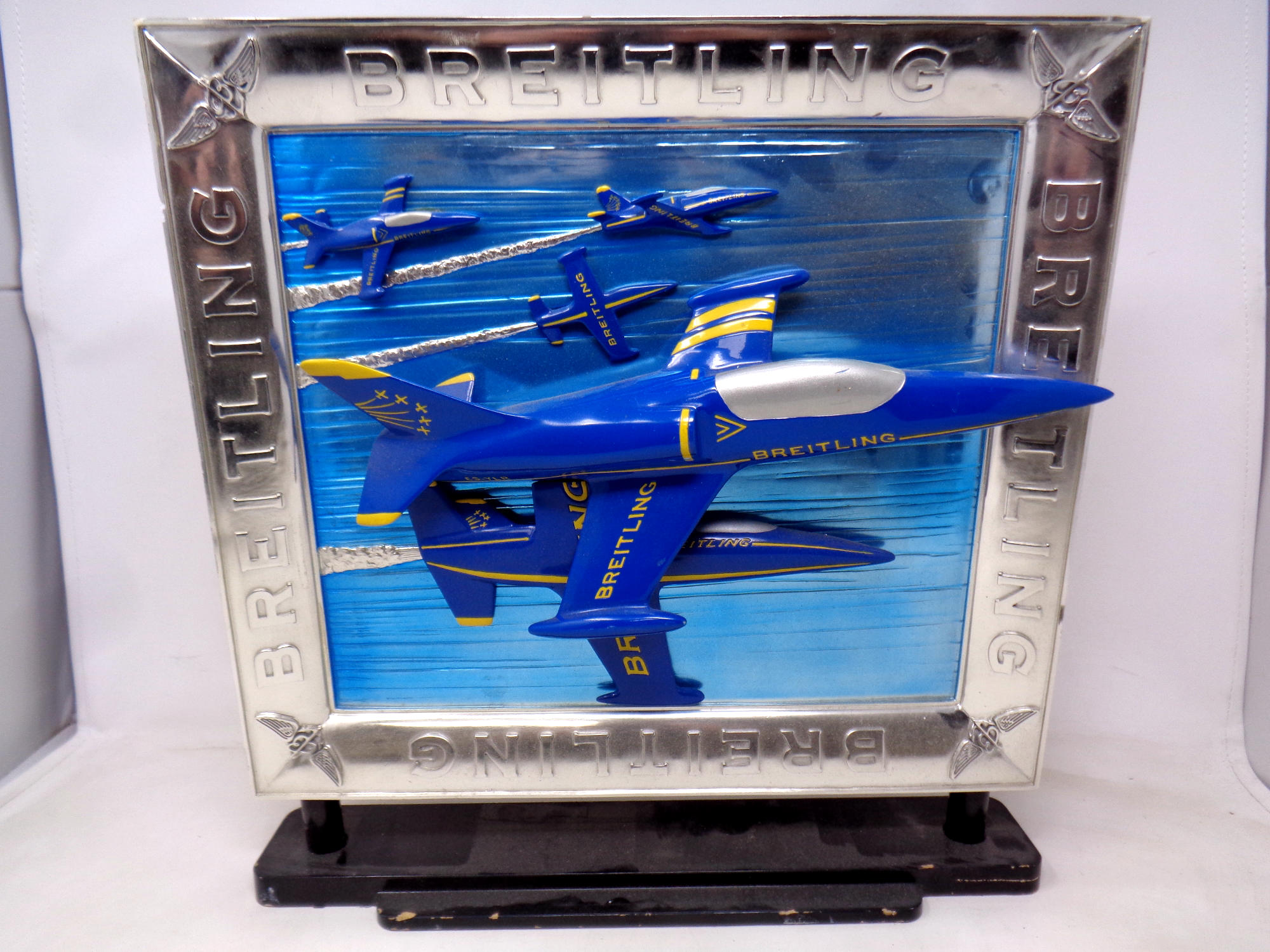 A Breitling twin sided shop advertising stand, one side with relief fighter jets. Height 39.