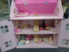 A contemporary dolls house with furniture and dolls.