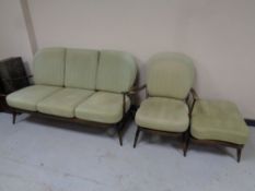 A three piece Ercol elm and beech lounge suite comprising of three seater settee,
