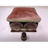 A silver and fabric pin cushion box decorated with silver shells containing a thimble (London