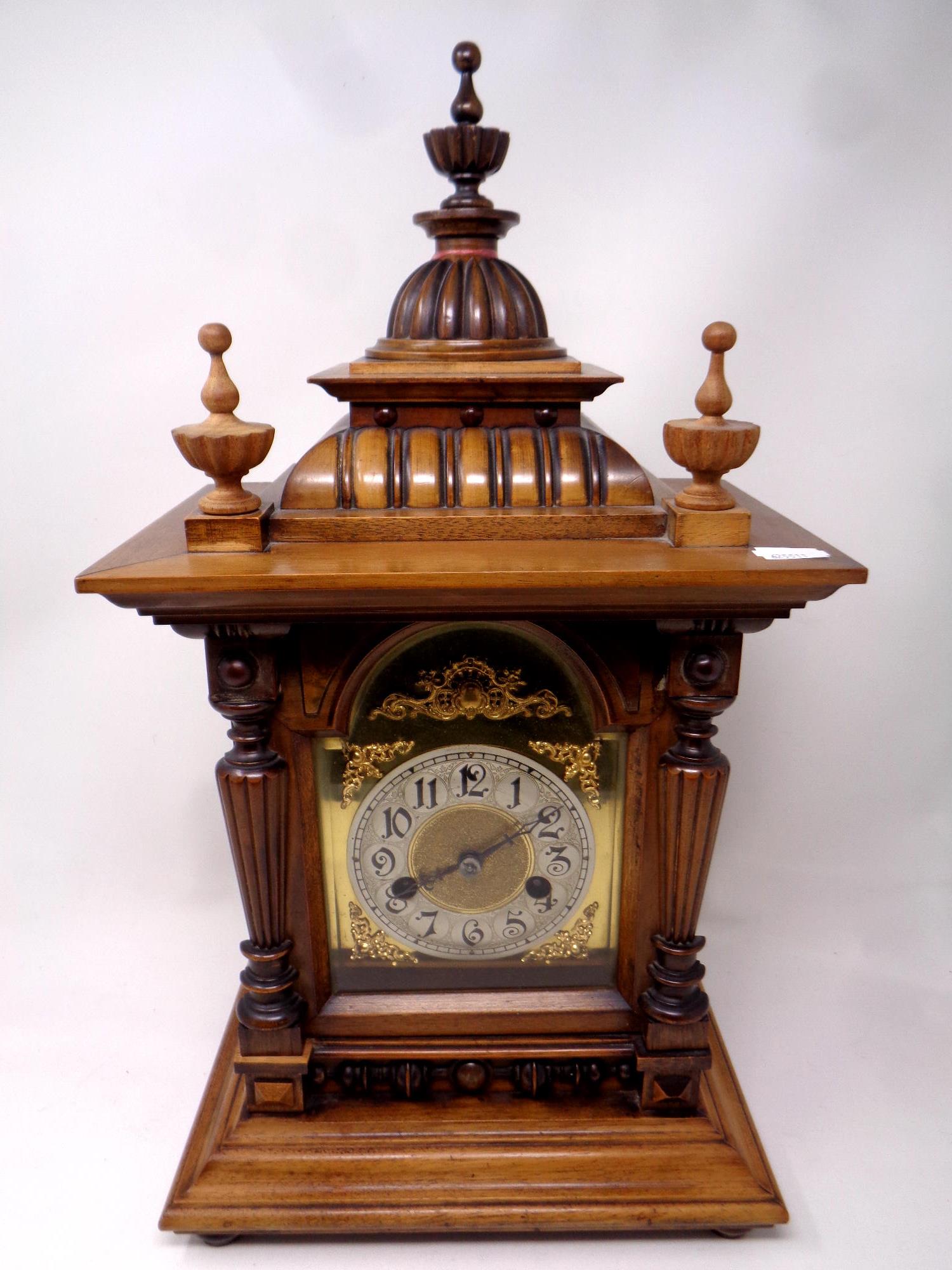 An Edwardian walnut cased mantel clock with brass dial