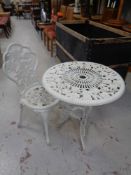 A cast metal patio table with chair