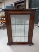 A 20th century oak leaded glass door corner cabinet on bun feet