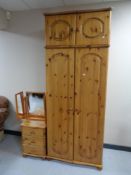 A pine double door wardrobe with top box together with a pine three drawer bedside chest and triple