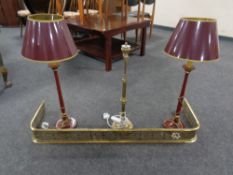 An antique brass fret work fender together with a brass two-way table lamp and a further pair of