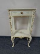 A cream and gilt French style two tier occasional table fitted a drawer on cabriole legs